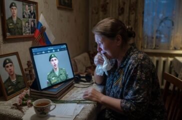A Russian family looking at a smartphone displaying an AI-generated face of a young soldier in a dimly lit living room